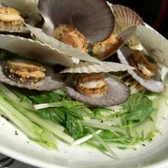 A picture of ホタテの稚貝と茨城産水菜のワイン蒸し.